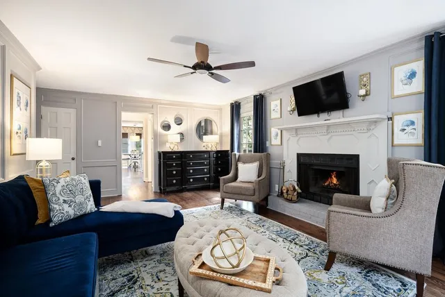 a living room with furniture a flat screen tv and a fireplace