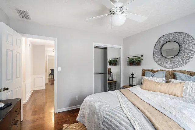 a bedroom with bed painting and wooden floor