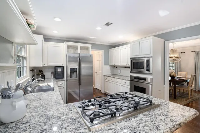 a kitchen with stainless steel appliances granite countertop a sink stove and refrigerator