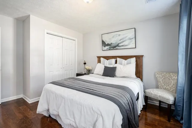 a bedroom with a bed and painting on the wall