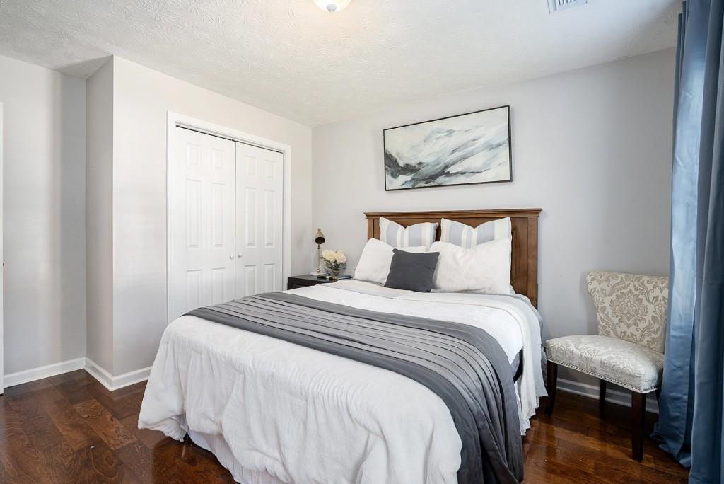 4682 Bentley Place Peachtree Corners, GA 30096 - Photo 32 of 44 a bedroom with a bed and a painting on the wall