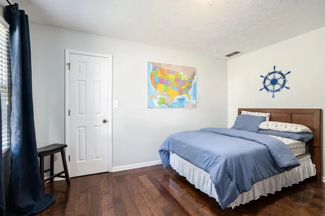 a bedroom with a large bed and a painting on the wall
