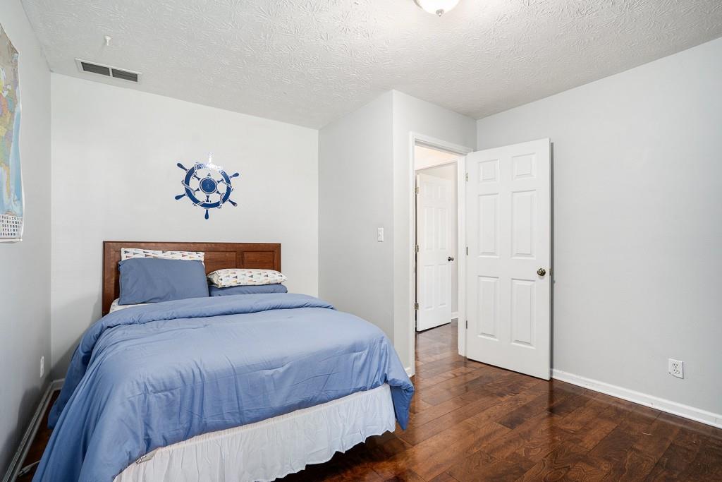 4682 Bentley Place Peachtree Corners, GA 30096 - Photo 34 of 44 a bedroom with a large bed and a painting on the wall