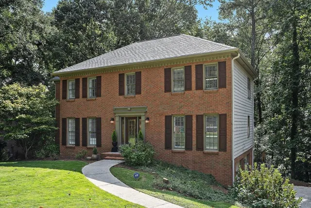 front view of a brick house with a yard