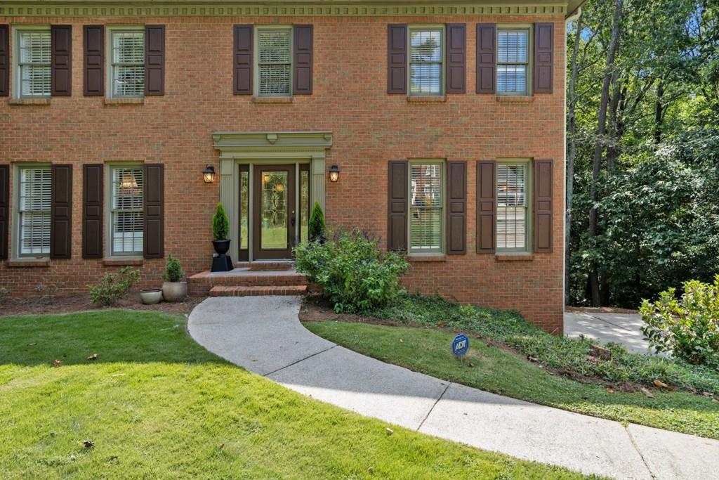 4682 Bentley Place Peachtree Corners, GA 30096 - Photo 10 of 44 front view of a brick house with a yard