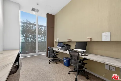 a view of a workspace with furniture and a window