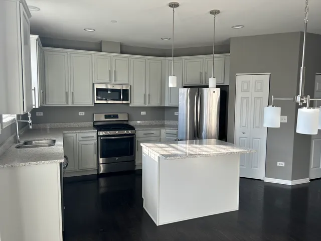 a kitchen with a stove a refrigerator and a sink