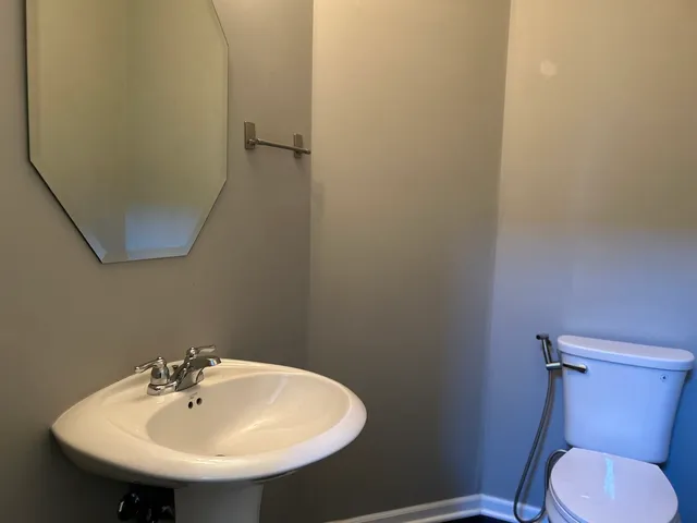 a bathroom with a sink mirror and toilet