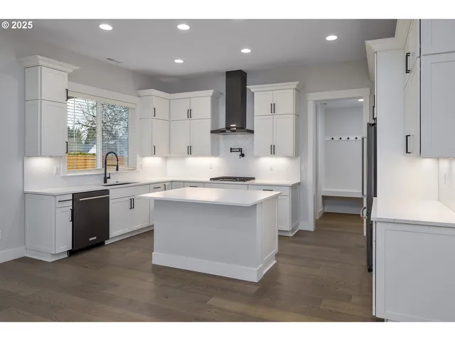 a kitchen with white cabinets and appliances
