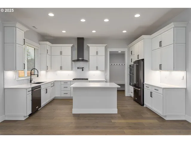 a kitchen with white cabinets appliances and sink
