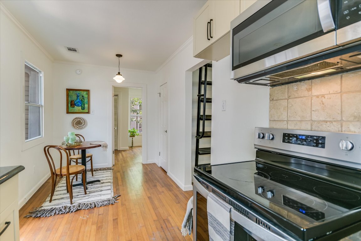 1110 West 22nd Street, Unit 16 Austin, TX 78705 - Photo 12 of 21 a kitchen with a stove and a table chair