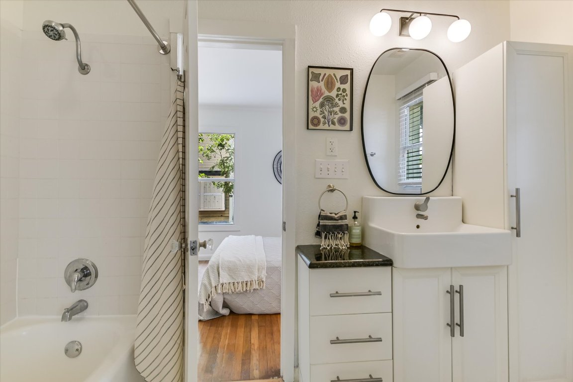 1110 West 22nd Street, Unit 16 Austin, TX 78705 - Photo 6 of 21 a bathroom with a sink a mirror and a bathtub
