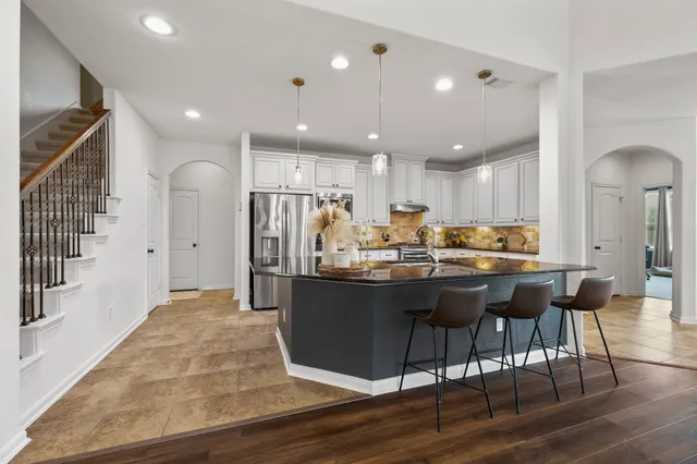 a kitchen with stainless steel appliances granite countertop a kitchen island a stove and a refrigerator