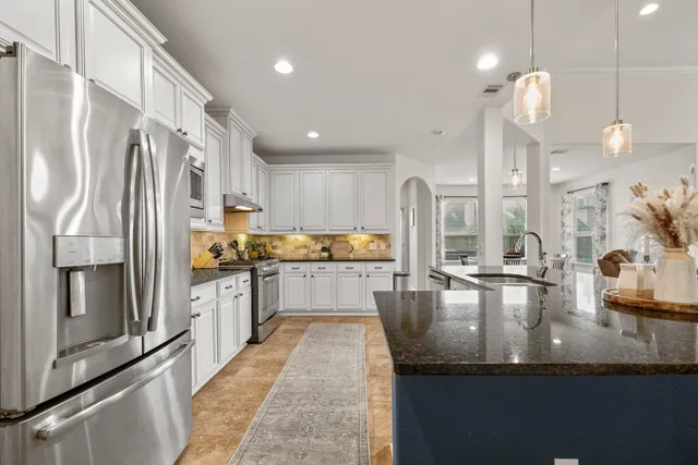 a kitchen with stainless steel appliances granite countertop a sink stove and refrigerator