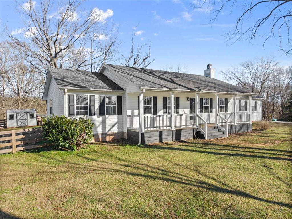 a view of a house with a big yard and large trees