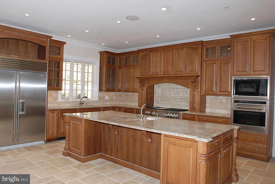 8539 Howell Road Bethesda, MD 20817 - Photo 9 of 22 a kitchen with stainless steel appliances granite countertop a sink a stove and a refrigerator