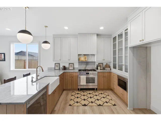 a kitchen with a sink a stove a refrigerator cabinets and a window