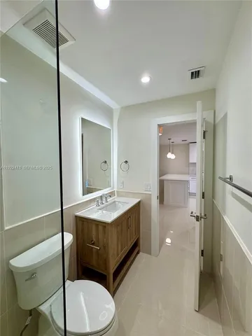 a bathroom with a sink a toilet a mirror and shower