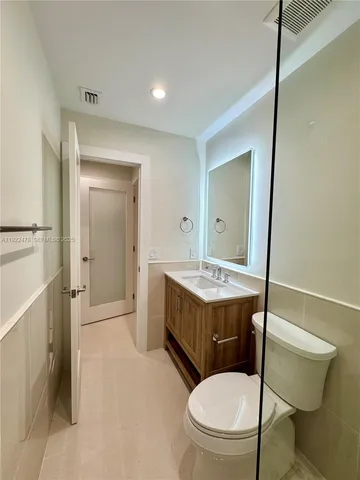 a bathroom with a sink a toilet and mirror