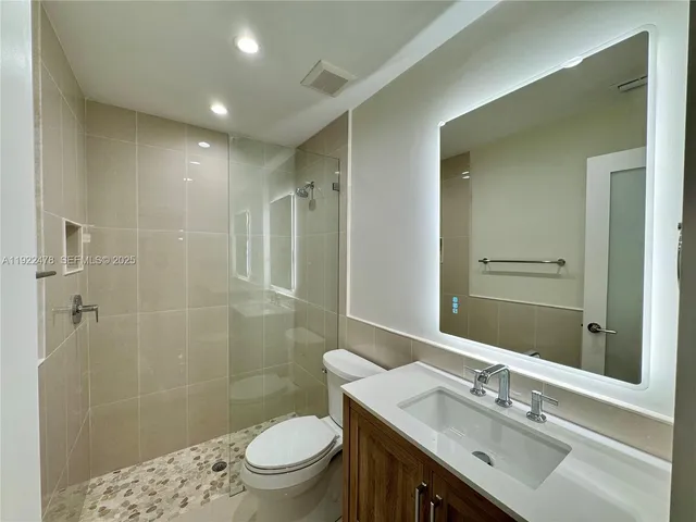 a bathroom with a sink a toilet and shower