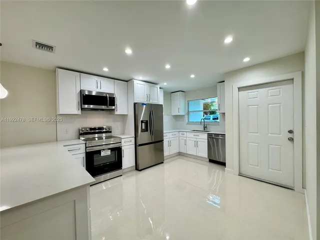 a kitchen with stainless steel appliances a refrigerator stove microwave and sink