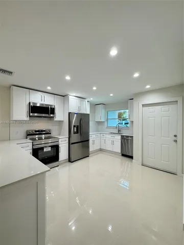 a kitchen with stainless steel appliances kitchen island granite countertop a stove and a sink
