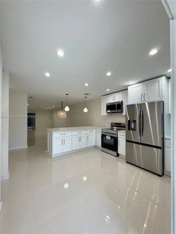 a view of kitchen with stainless steel appliances a refrigerator and a stove top oven