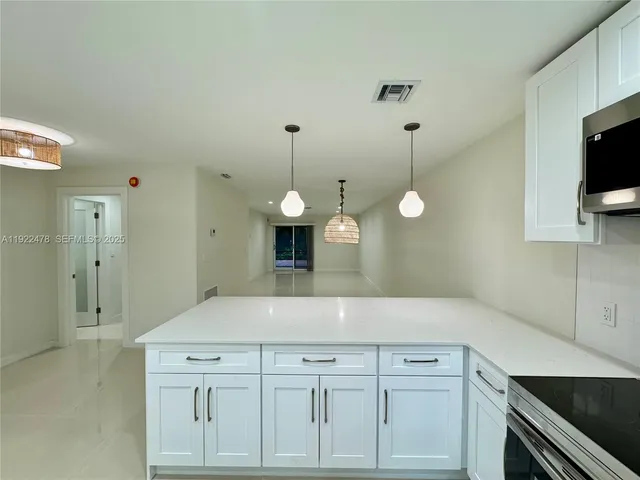 a kitchen with white cabinets and black appliances