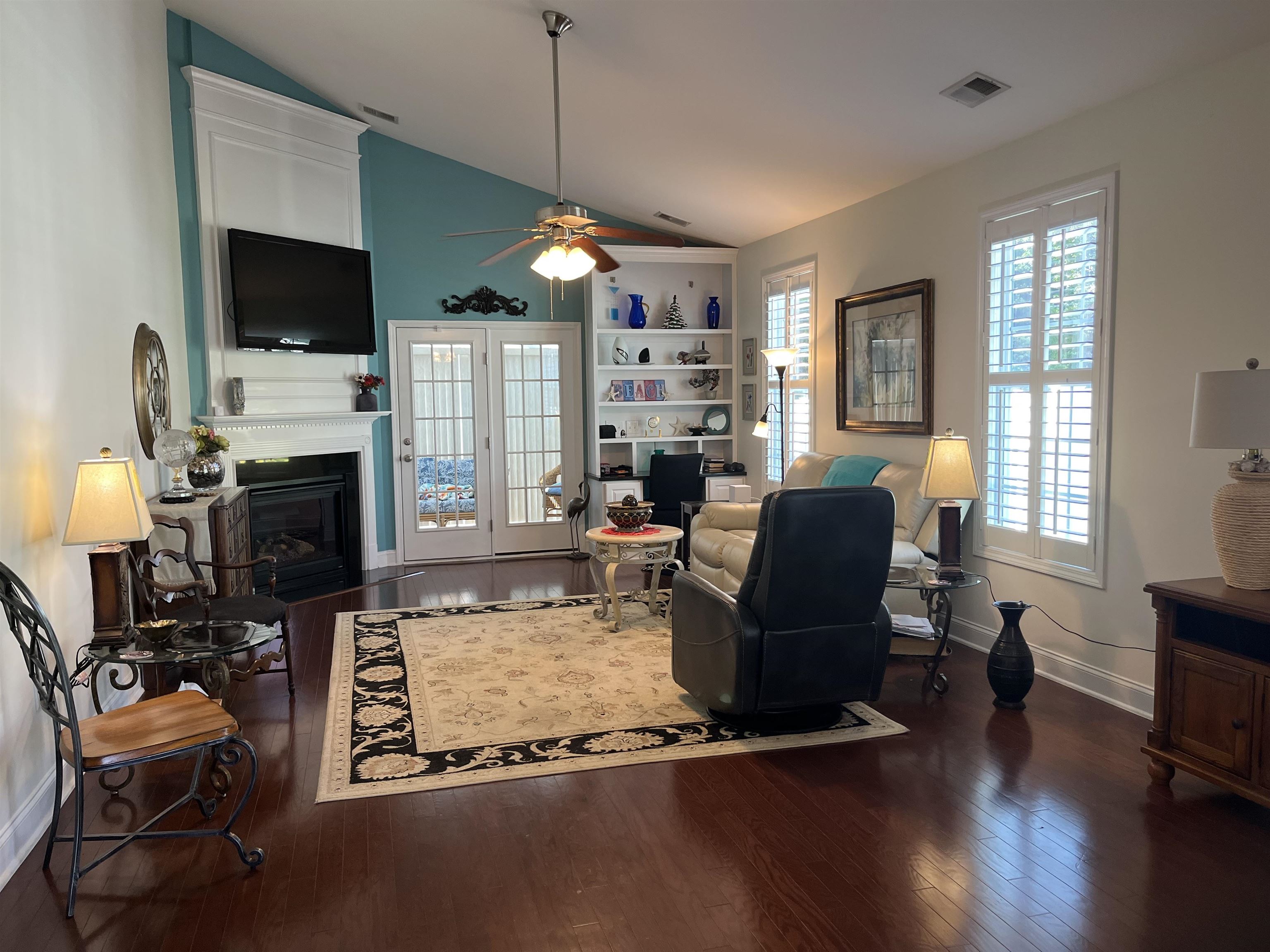 151 Coral Beach Circle Myrtle Beach, SC 29575 - Photo 13 of 40 Living room featuring lofted ceiling, a glass covered fireplace, dark wood-style floors, and ceiling fan