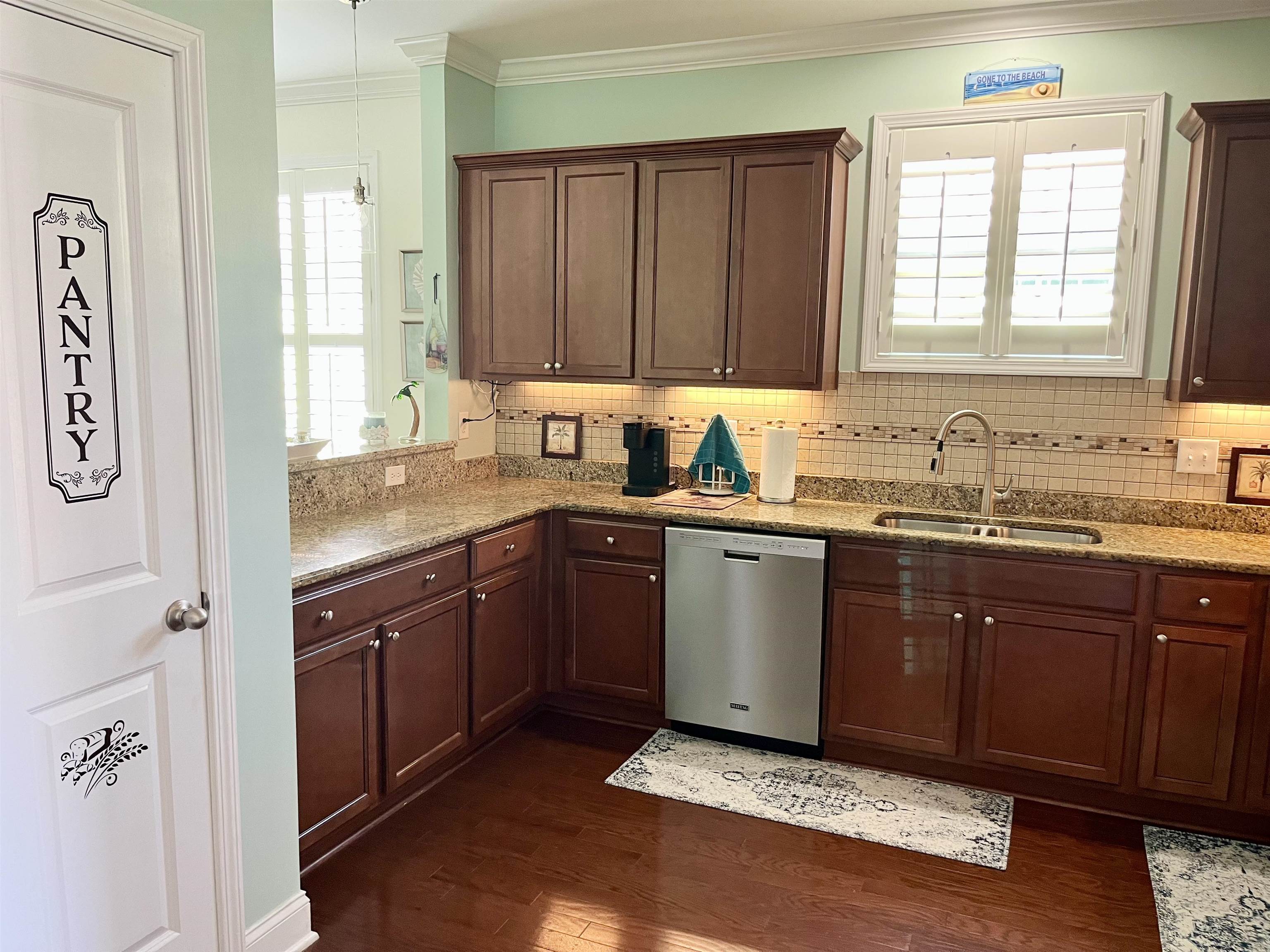 151 Coral Beach Circle Myrtle Beach, SC 29575 - Photo 10 of 40 Kitchen featuring light stone countertops, dishwasher, dark wood-type flooring, ornamental molding, and decorative backsplash