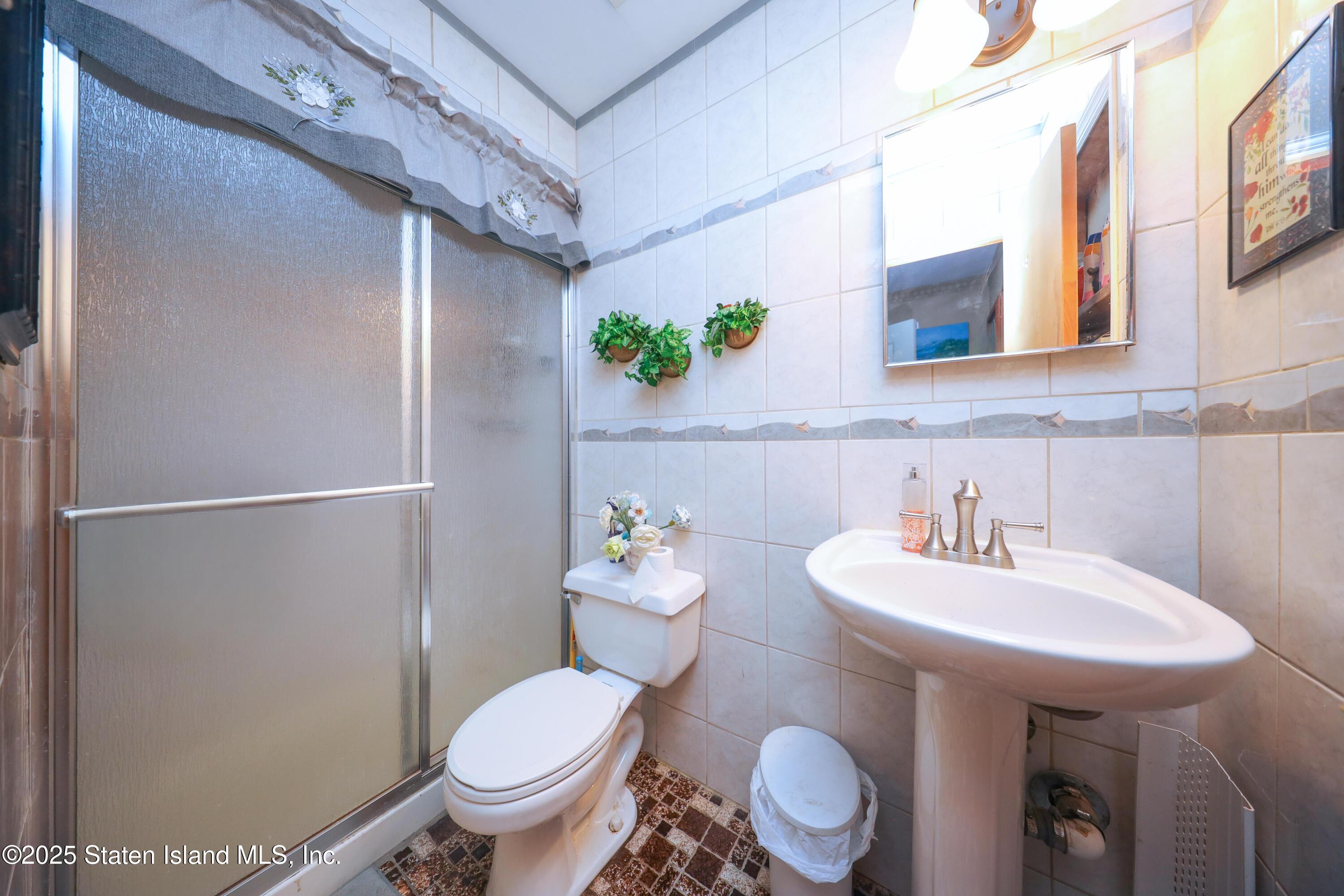 268 Ada Drive Staten Island, NY 10314 - Photo 16 of 27 a bathroom with a sink toilet and a mirror