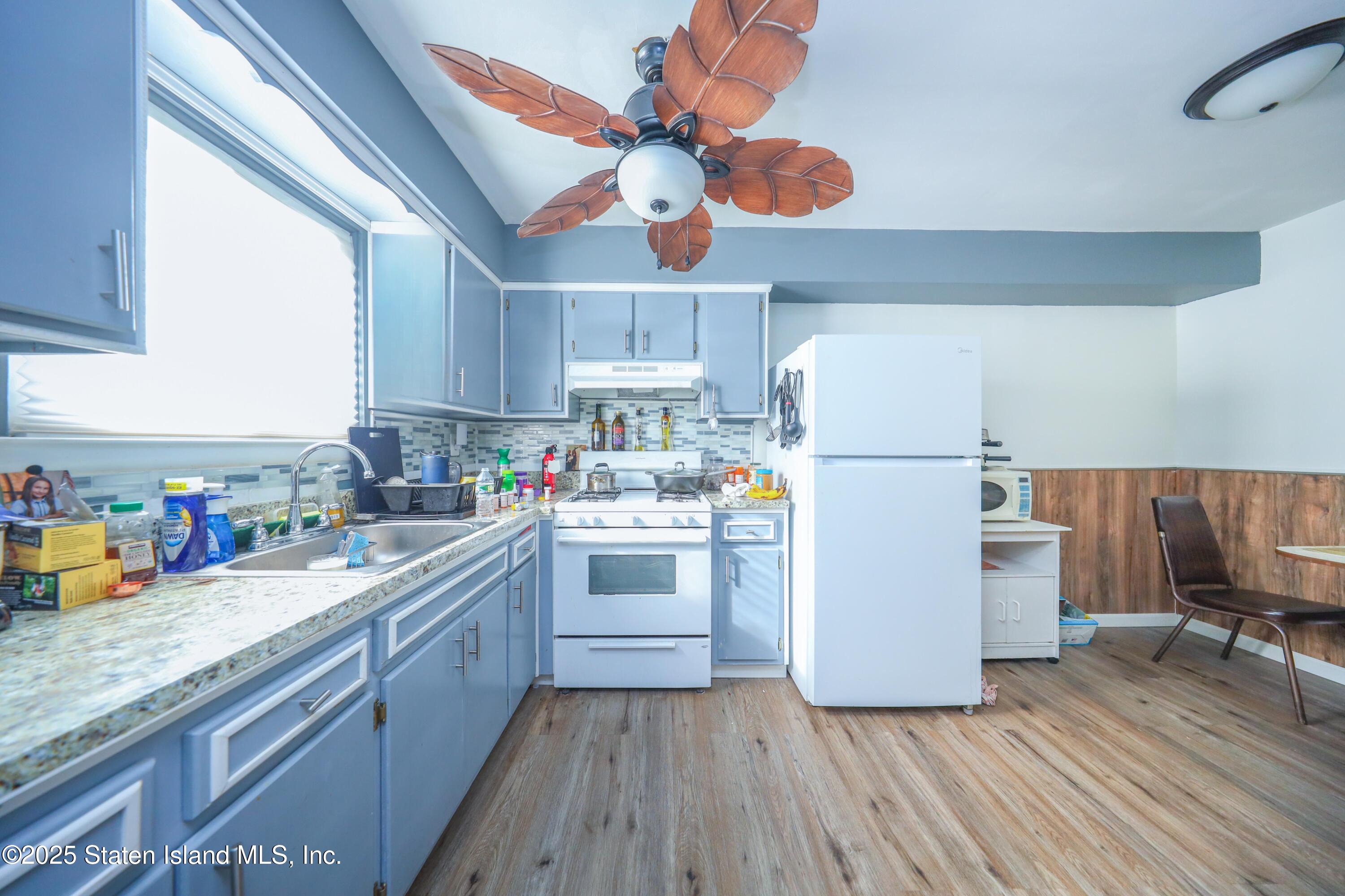 268 Ada Drive Staten Island, NY 10314 - Photo 18 of 27 a kitchen with a refrigerator a stove cabinets dining table and chairs
