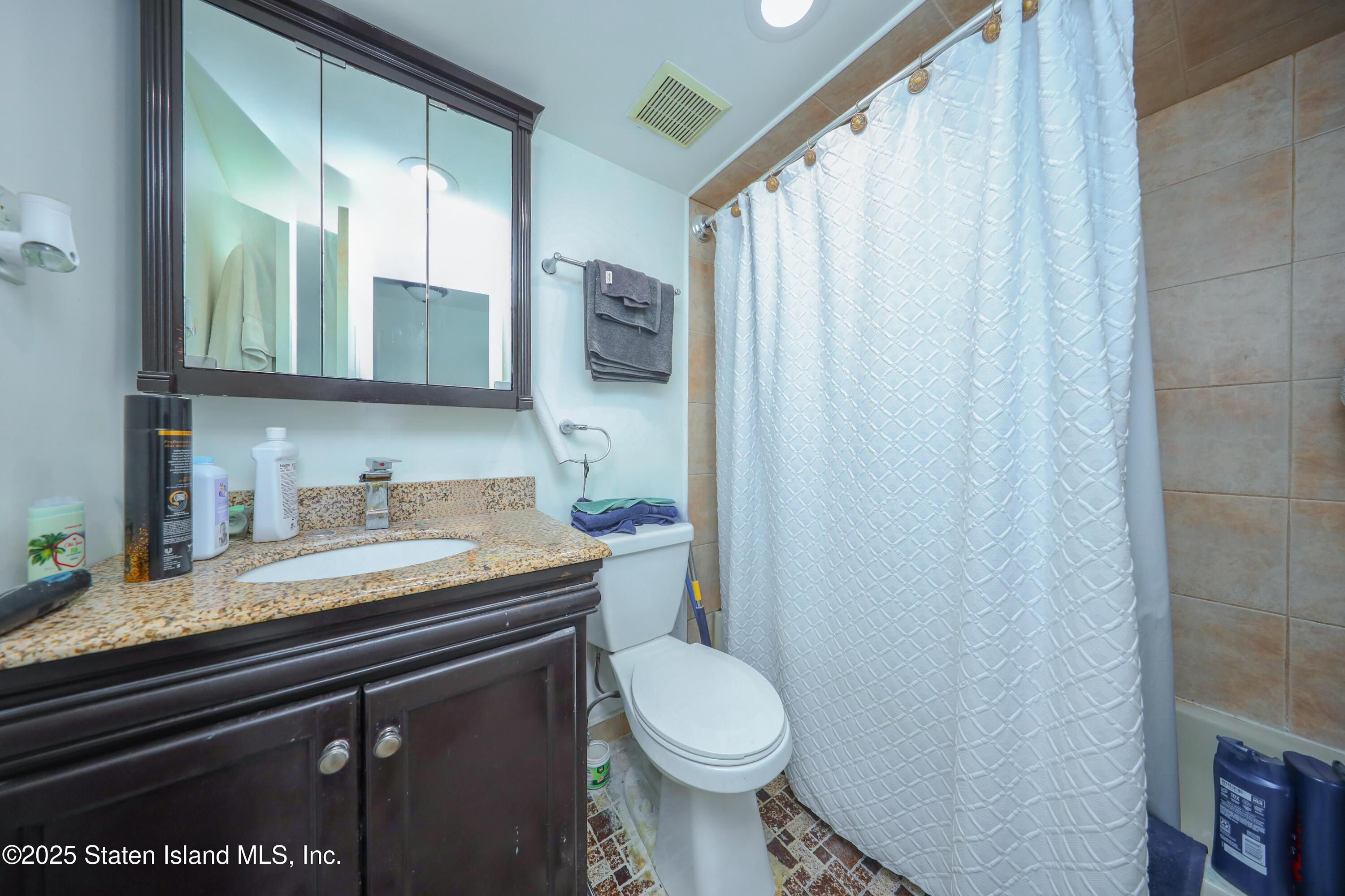 268 Ada Drive Staten Island, NY 10314 - Photo 21 of 27 a bathroom with a granite countertop sink toilet and mirror