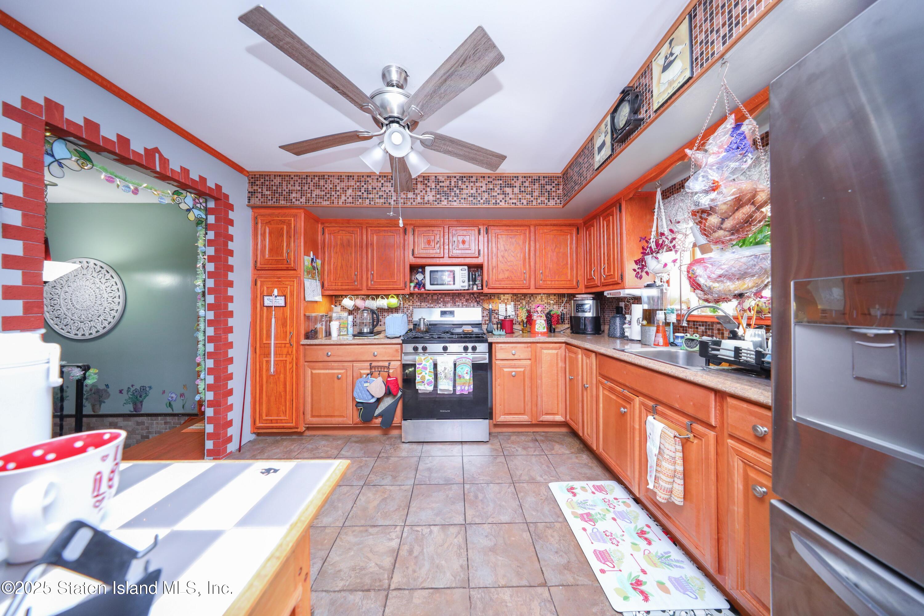 268 Ada Drive Staten Island, NY 10314 - Photo 7 of 27 a large white kitchen with a large window a counter space and stainless steel appliances