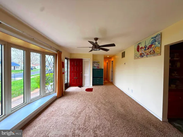 a view of a livingroom with a ceiling fan and window