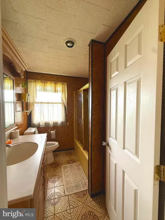 a bathroom with a tub sink and mirror