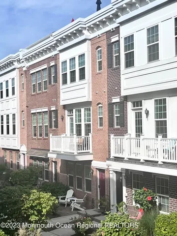 a front view of a house with a garden and sitting area