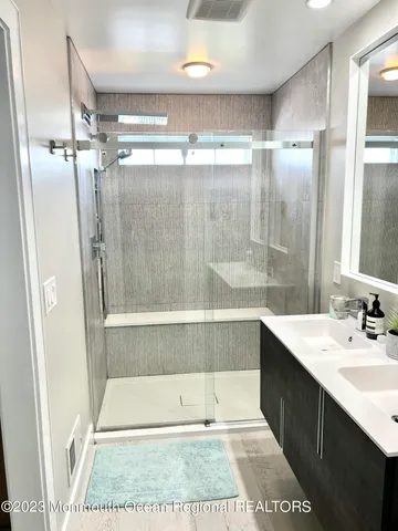 a bathroom with a sink shower and a mirror