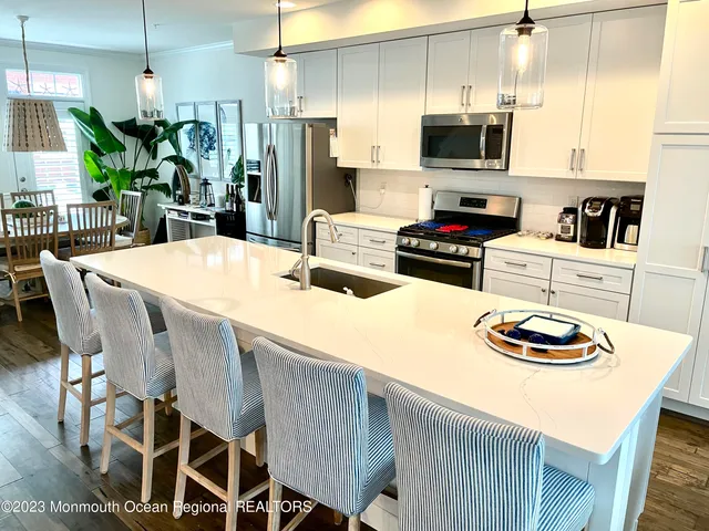 a kitchen with stainless steel appliances kitchen island granite countertop a stove a kitchen island and a refrigerator