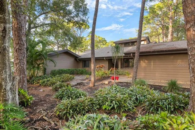 a view of a house with a small yard and a large tree