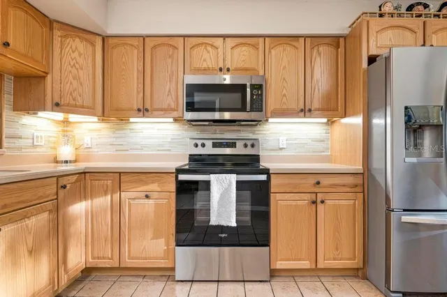 a kitchen with granite countertop a refrigerator stove and microwave