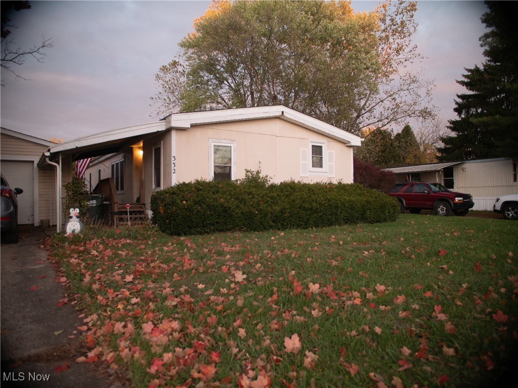 332 Max Road Lodi, OH 44254 - Photo 22 of 22 Property exterior at dusk featuring a garage and a lawn