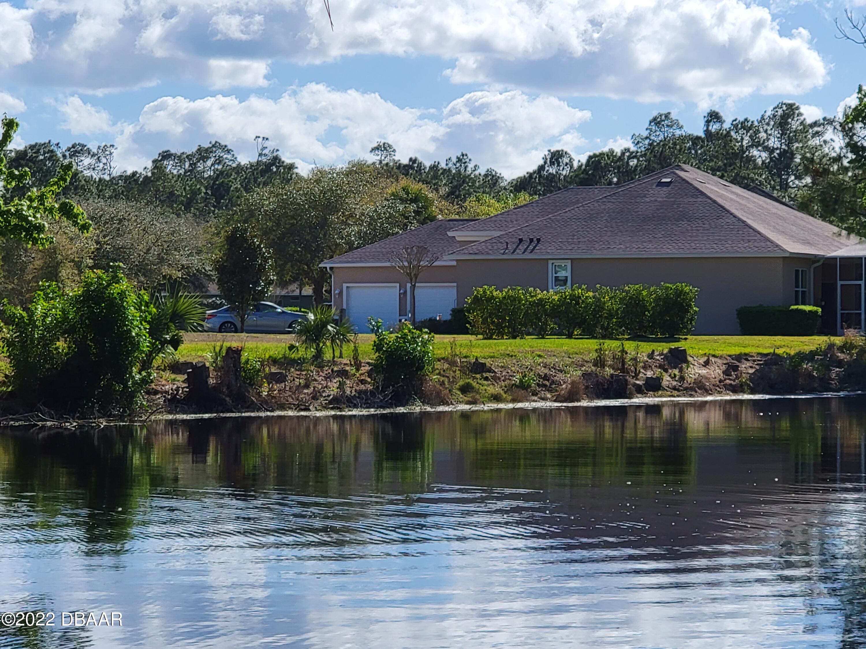 1464 Kinnard Circle Ormond Beach, FL 32174 - Photo 2 of 18 a view of a lake with a house in the background