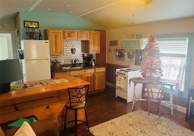 a room with stainless steel appliances kitchen island granite countertop furniture and a wooden floor