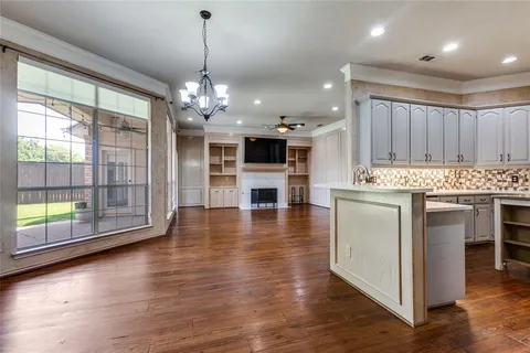 a open kitchen with stainless steel appliances granite countertop a stove top oven a refrigerator and a wooden floors
