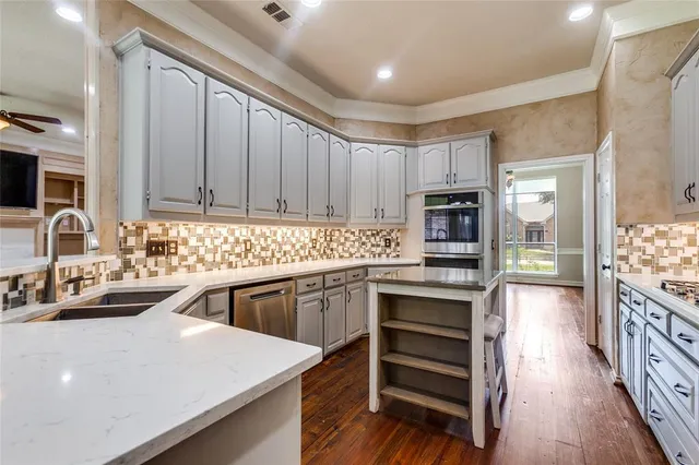 a kitchen with kitchen island granite countertop a sink stove and cabinets
