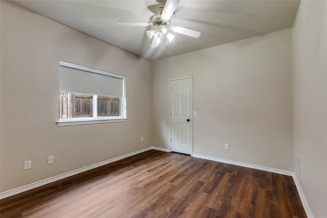a view of a big room with wooden floor and a chandelier fan