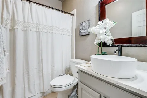 a bathroom with a sink a toilet and a mirror