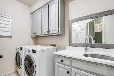 a view of a sink and washer dryer