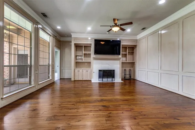 a view of a livingroom with an empty space wooden floor and a window